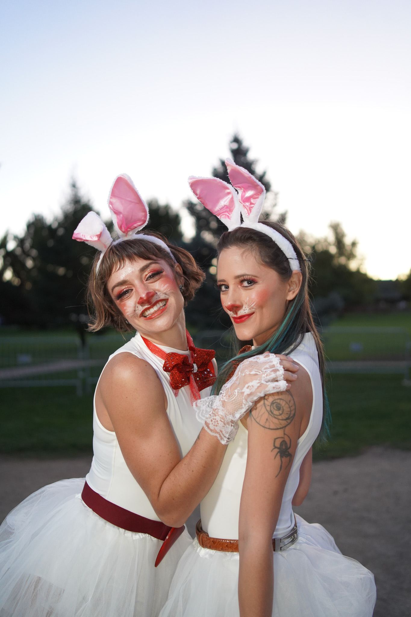 Two dancers in bunny ears, white dresses and red bow ties