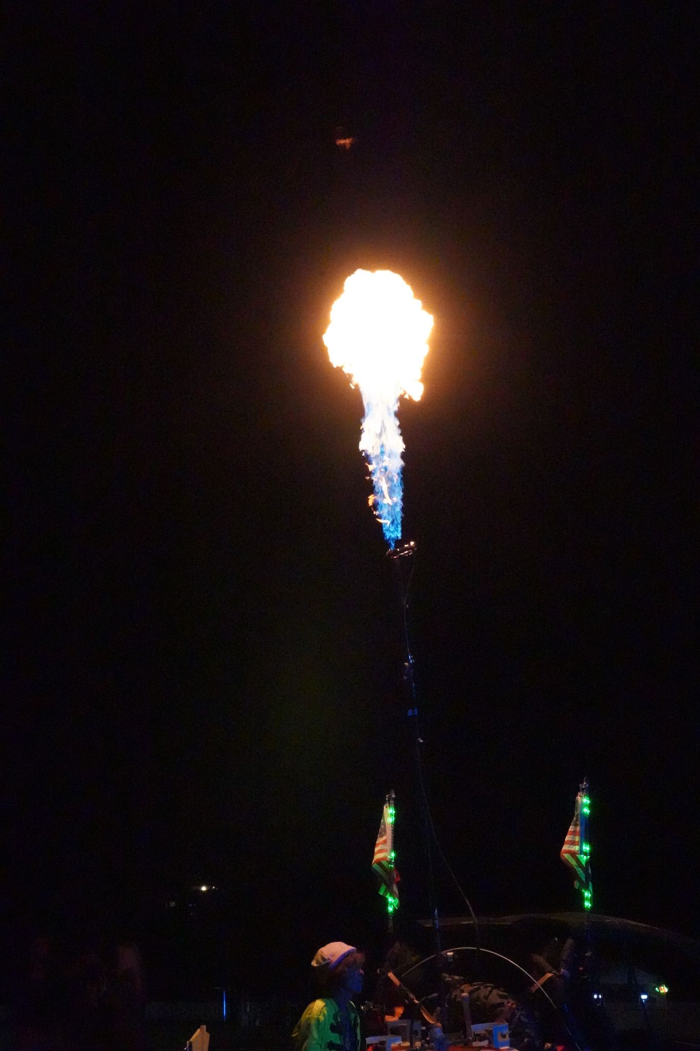 A burst of flame shooting into the night sky above the crowd